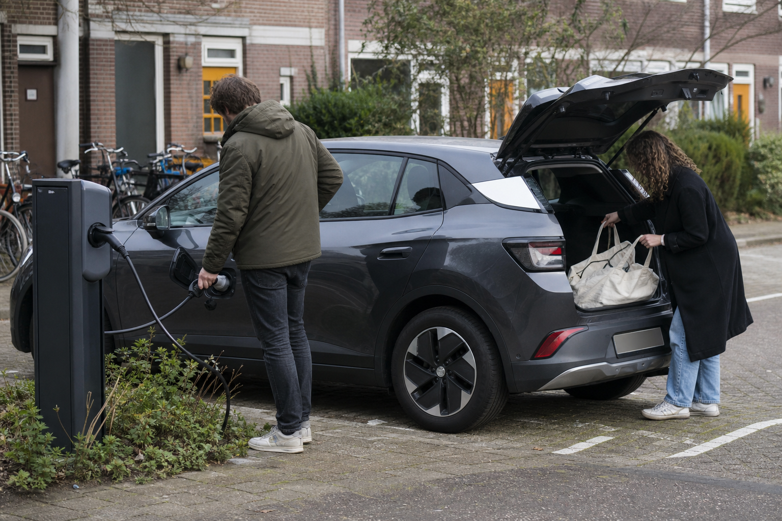 Twee mensen laden een elektrische deelauto op een rustige parkeerplaats